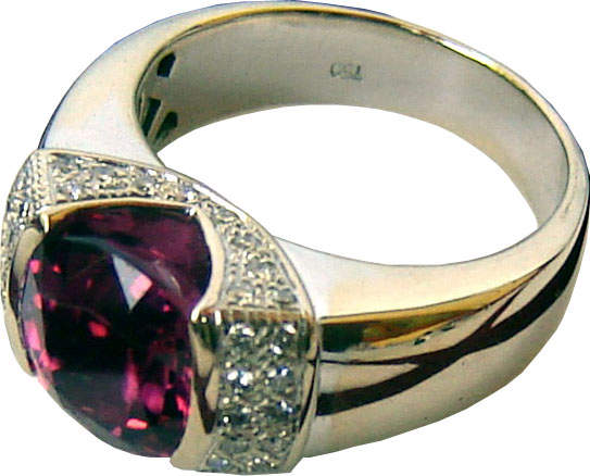 Ring with a large cushion cut rhodolite garnet in the center with diamonds on either side.