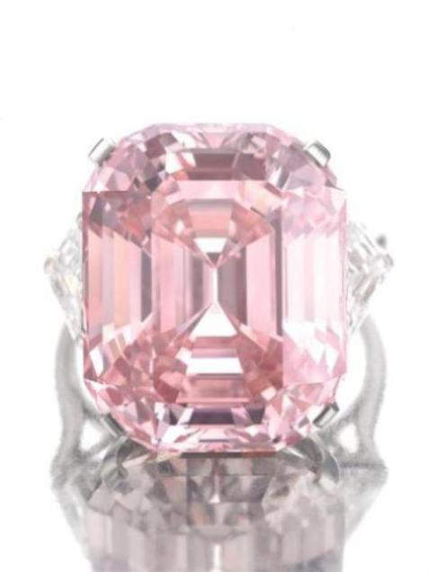 Graff Pink Diamond mounted on a ring flanked by two shield-shaped white diamonds