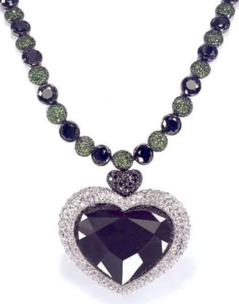 Heart-shaped Gruosi diamond set as the centerpiece of a pendant to a black and white diamond, tsavorite garnet necklace 