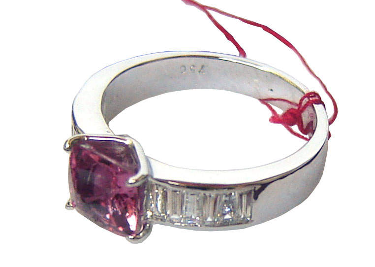 Ring with a large cushion cut Ceylon Pink Sapphire in the center with diamonds on either side